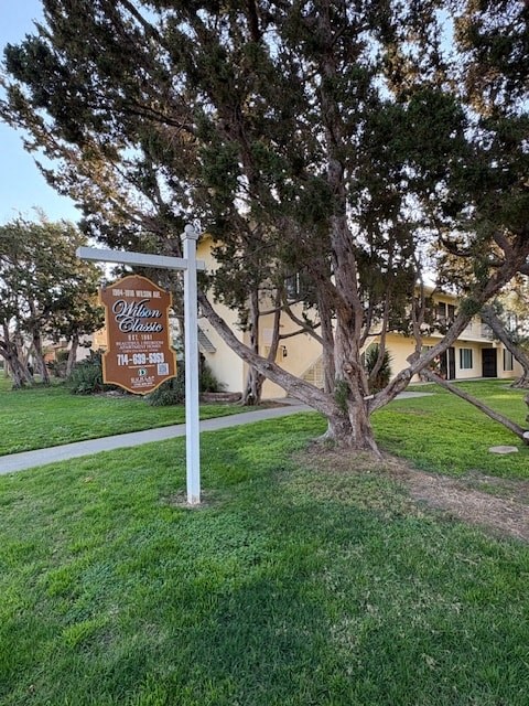 A sign for Olliwood Estates is in front of a tree.