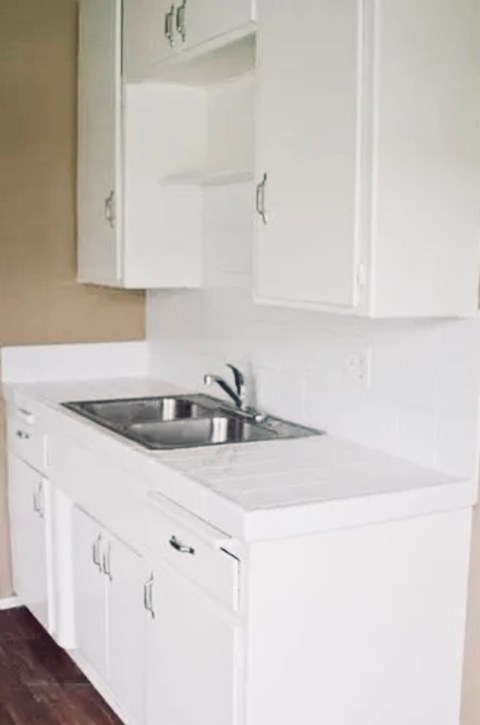 A white kitchen with a sink and cabinets.