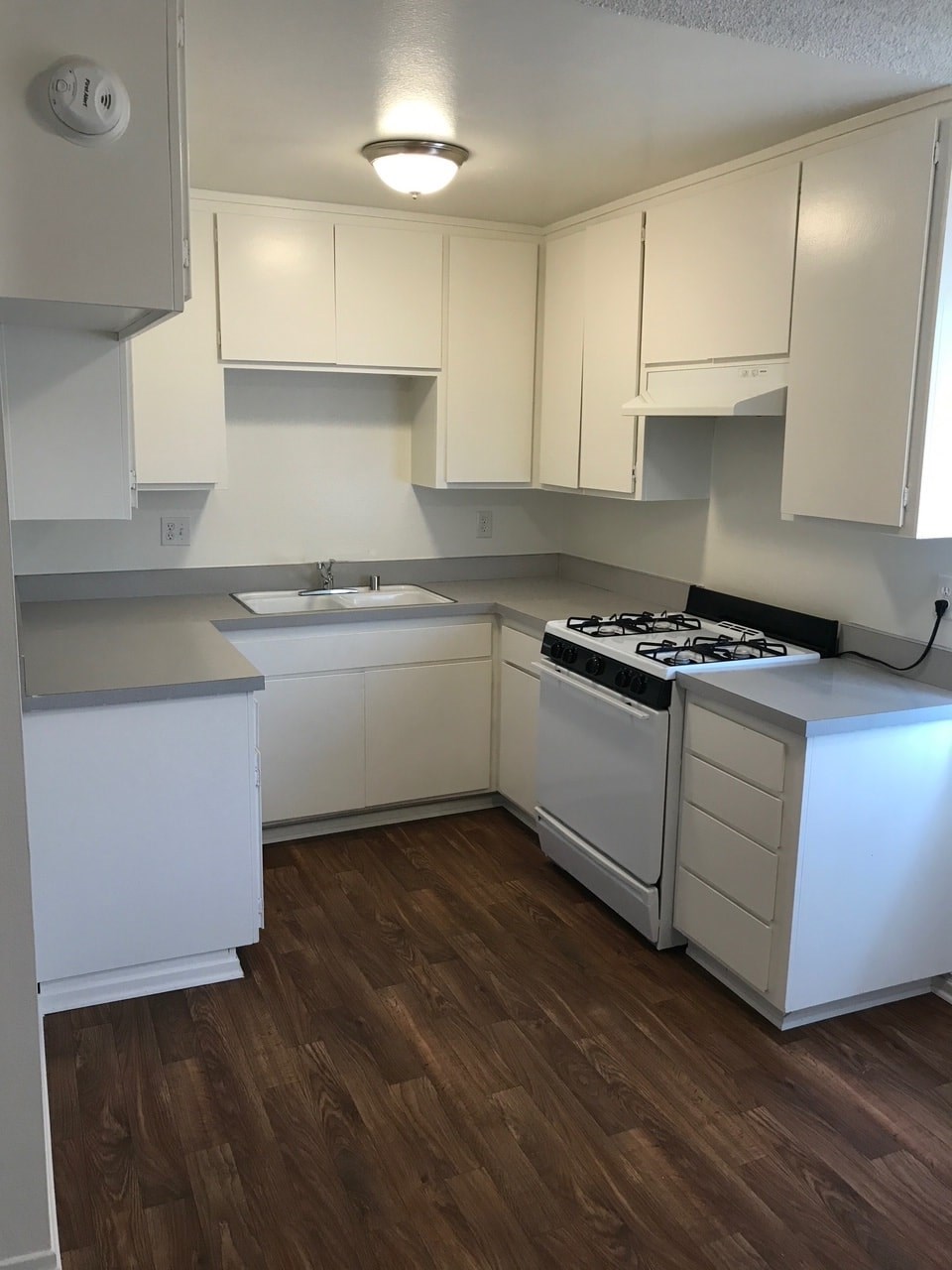A kitchen with white cabinets and a black stove top.