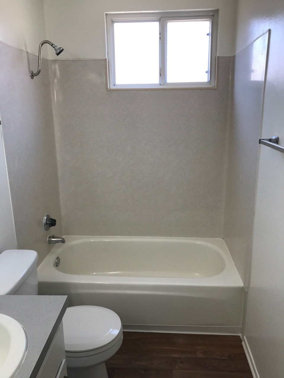 A white toilet sits next to a white bathtub in a bathroom.