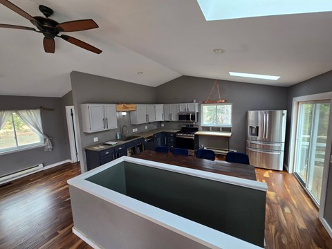 A modern kitchen with a skylight and a large island.