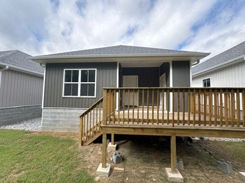 A house with a grey exterior and a wooden deck.
