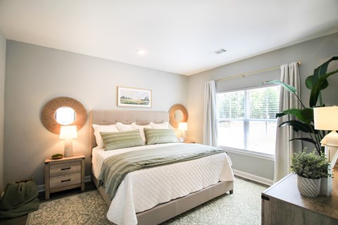 A bedroom with a large bed and two lamps on either side of the bed.