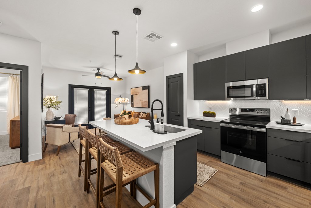 A modern kitchen with a large island and wooden floors.