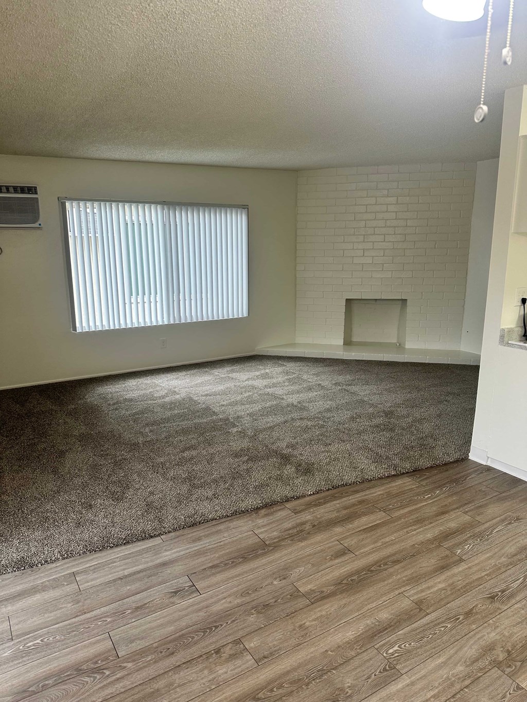 A room with a window and a fireplace.