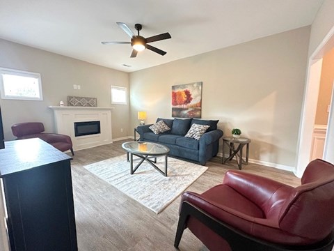 A living room with a red leather chair and a grey sofa.