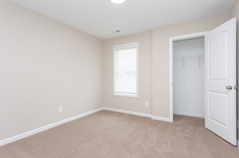A room with a white door and a window with blinds.