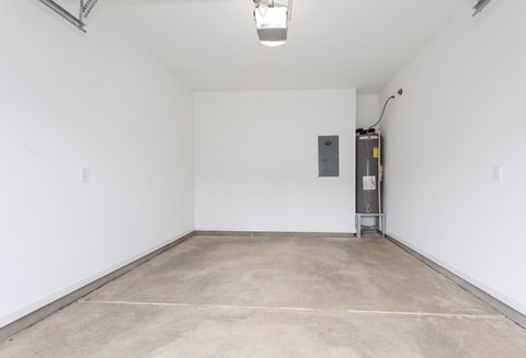 A large empty room with a concrete floor and white walls.