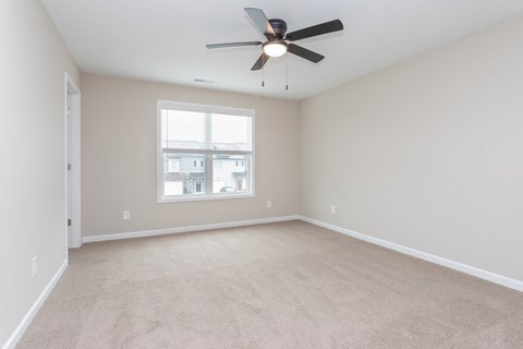 Empty room with a ceiling fan and a window.
