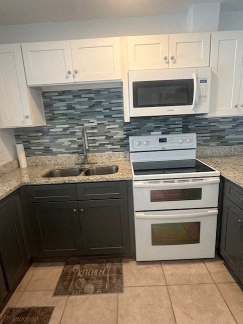 A kitchen with a white stove and black cabinets.