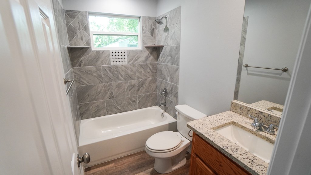 A bathroom with a toilet, sink, and bathtub.
