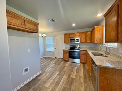 A kitchen with wooden cabinets and a stainless steel oven.