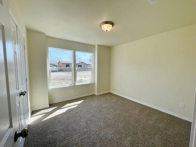 A room with a carpeted floor and a door on the left.