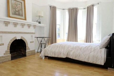 A bedroom with a fireplace and a bed.