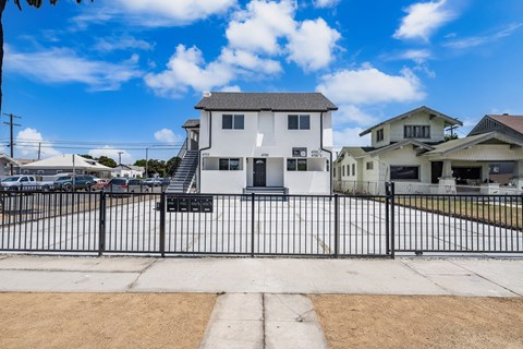 A white house with a black fence in front of it.