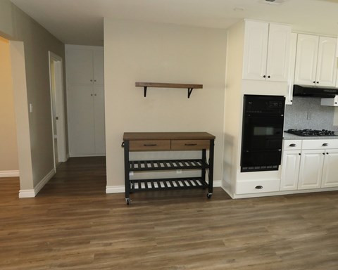 A kitchen with white cabinets and a black oven.