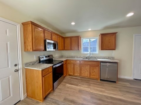 A kitchen with wooden cabinets and a granite countertop.