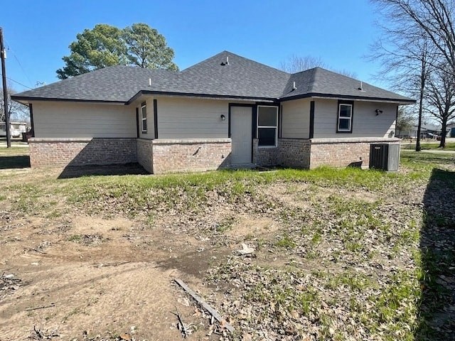 A house with a grey roof and a dirt area in front.