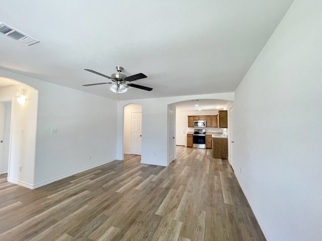 A room with a ceiling fan and wooden flooring.