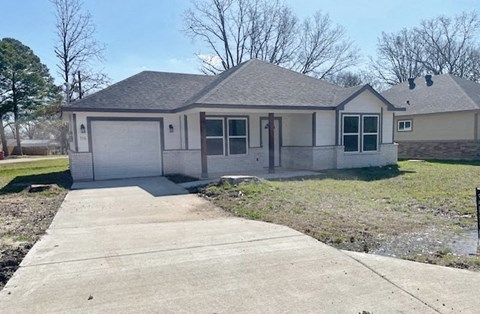 A house with a grey roof and white garage door.