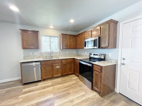 A kitchen with wooden cabinets and a white door.