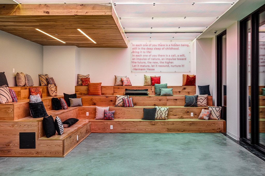 A room with a wooden floor and a wall with a quote on it.