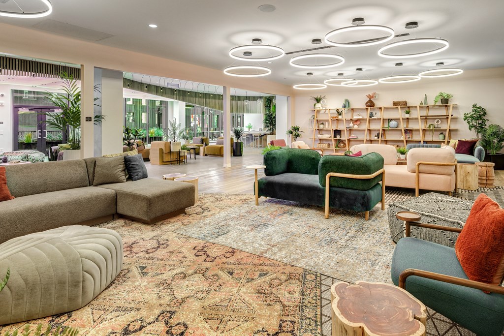 A living room with a rug and a variety of seating options.