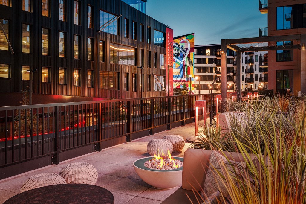 A modern outdoor seating area with a fire pit and seating options.