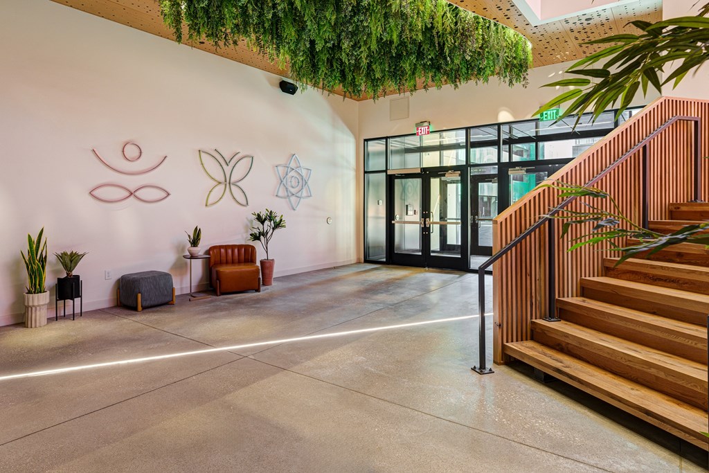 A hallway with a staircase and a wall with symbols on it.