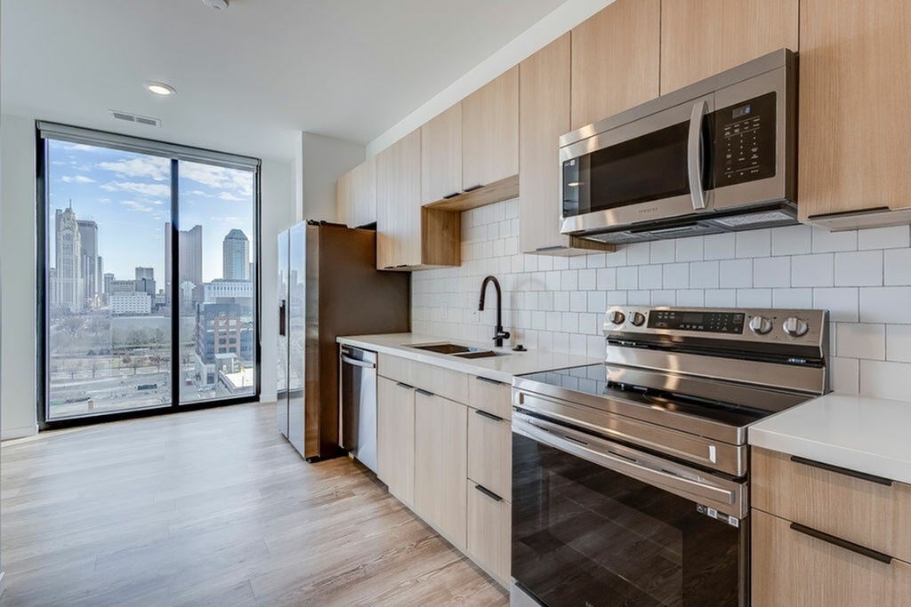 A modern kitchen with wooden cabinets and stainless steel appliances.