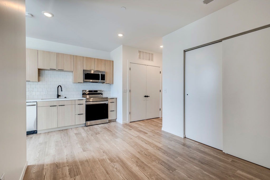 A kitchen with wooden floors and white walls.