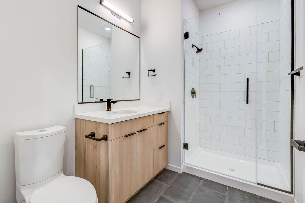 A white toilet sits next to a sink in a bathroom.