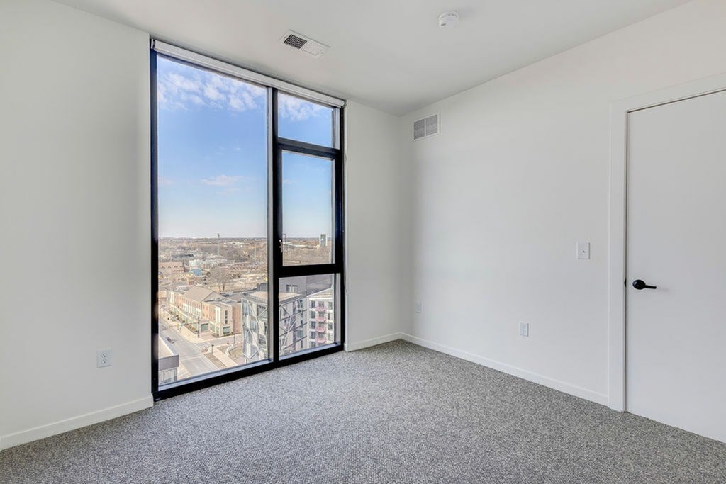 A room with a view of the city through large windows.