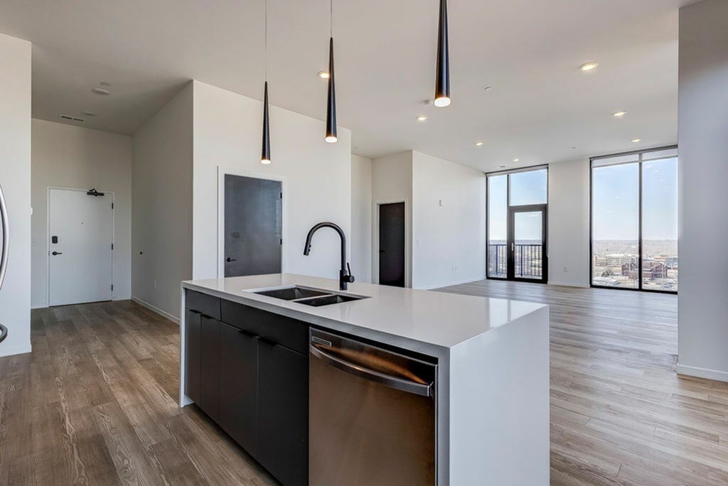 A modern kitchen with a large island and a view of the city.