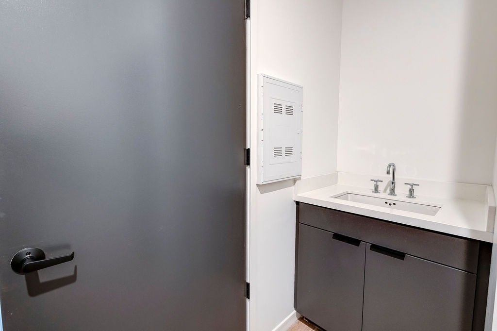 A bathroom with a sink and a door.