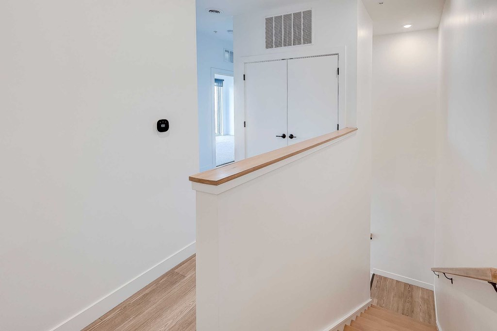 A white wall with a black square object on it.