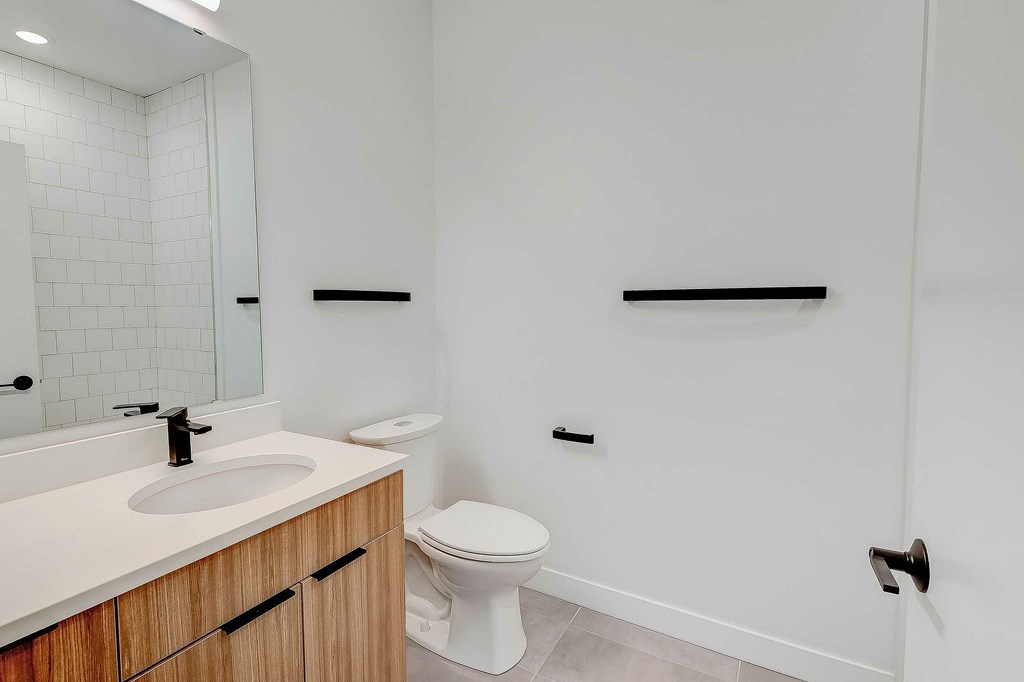 A white toilet sits in a bathroom next to a sink.