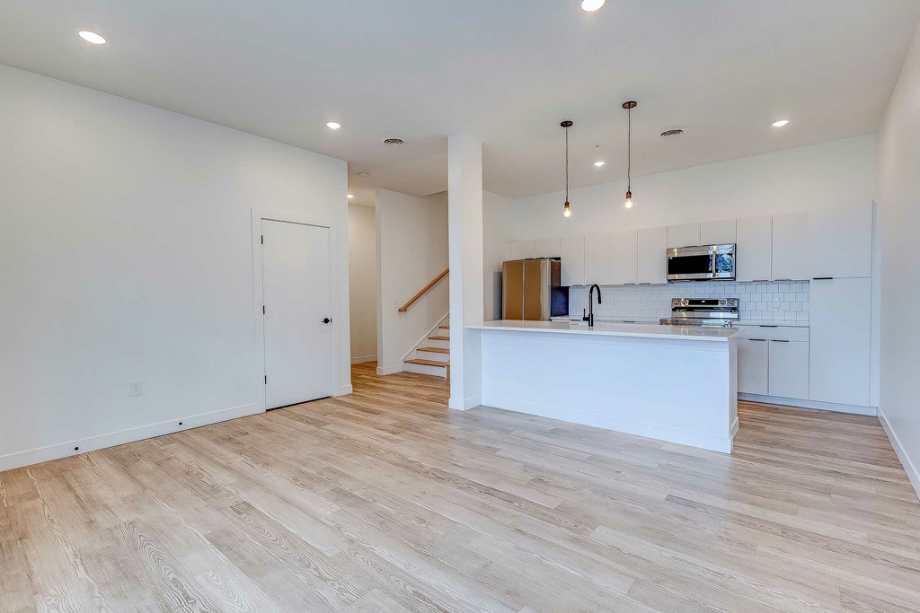 A spacious kitchen with a staircase leading to the upper floor.