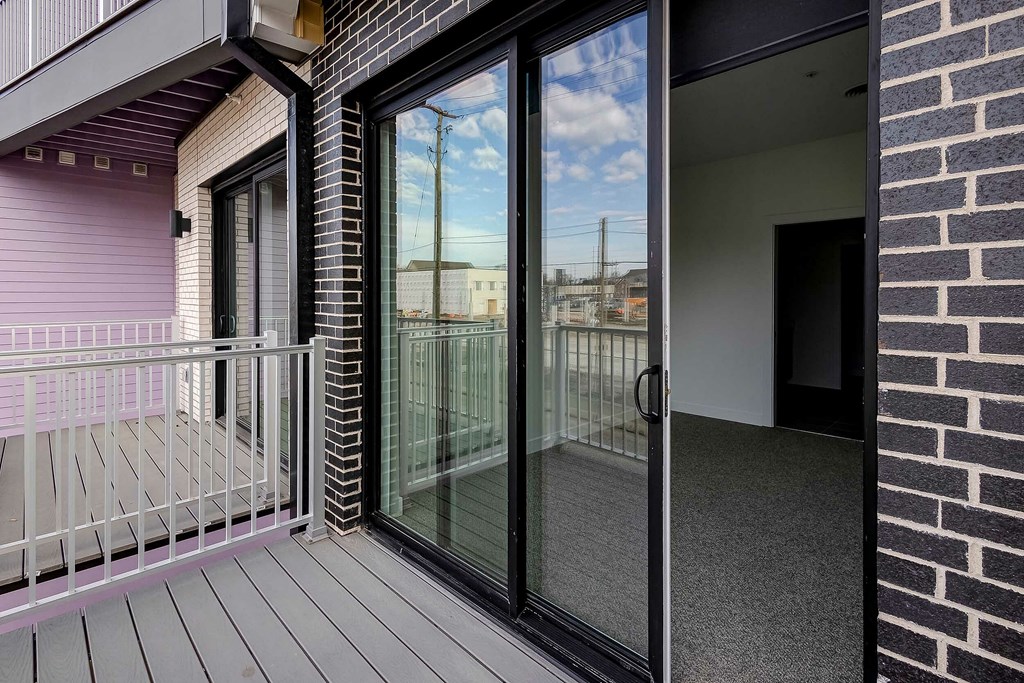 A balcony with a glass door and a metal railing.