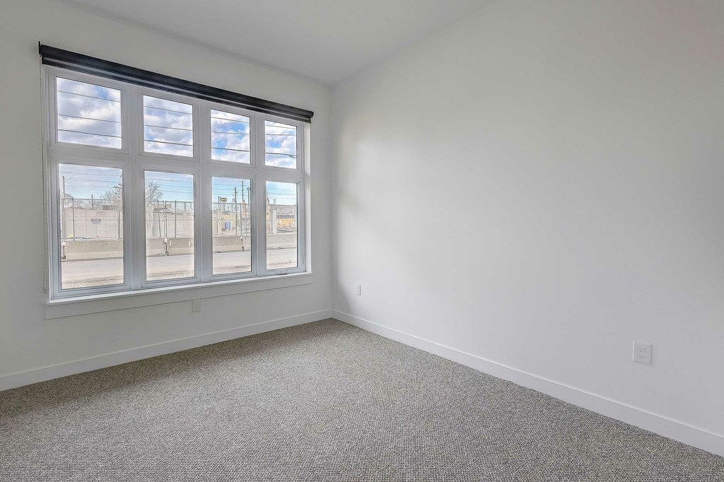 A room with a large window and carpeted floor.