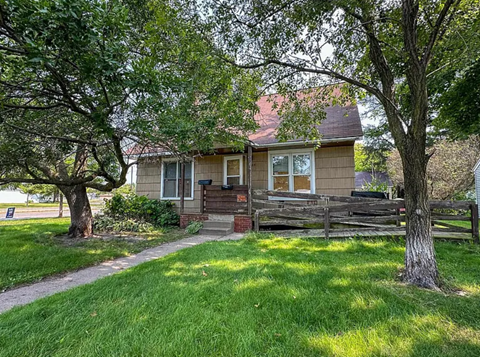 A house with a brown roof and a wooden fence.