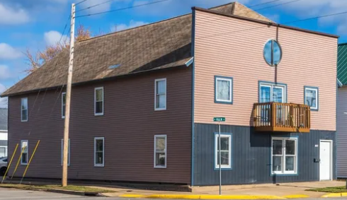 A two-story building with a balcony on the second floor.