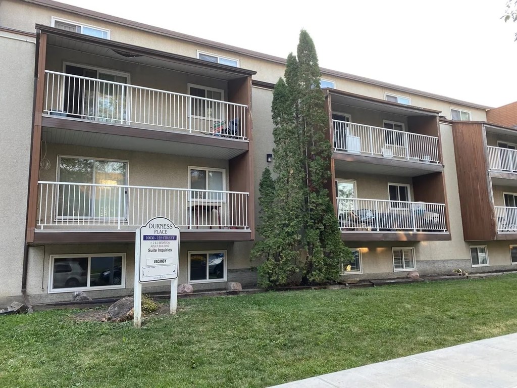A sign in front of a building that says "Dover Park Suite Apartments".