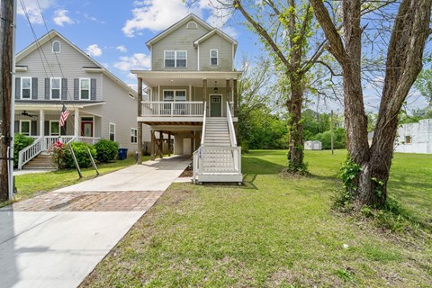 A two-story house with a flag on the porch.