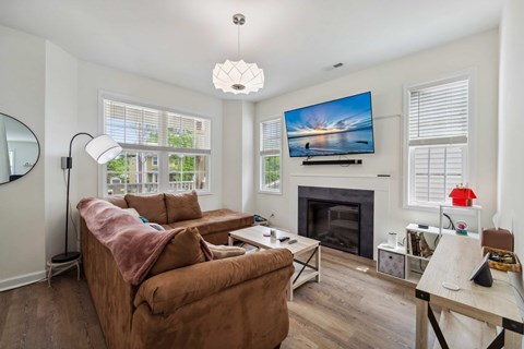 A living room with a brown couch and a fireplace.