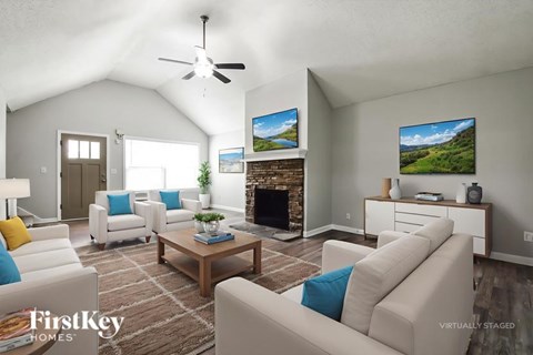 A living room with a fireplace and a television on the wall.