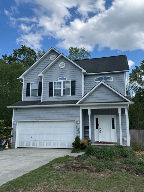 A grey house with a white garage door.