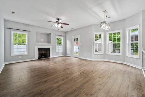A spacious room with a fireplace and a ceiling fan.