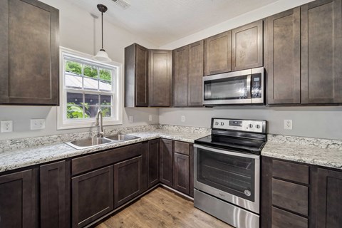 A kitchen with dark wood cabinets and stainless steel appliances.