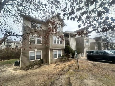 A two-story house with a car parked in front.